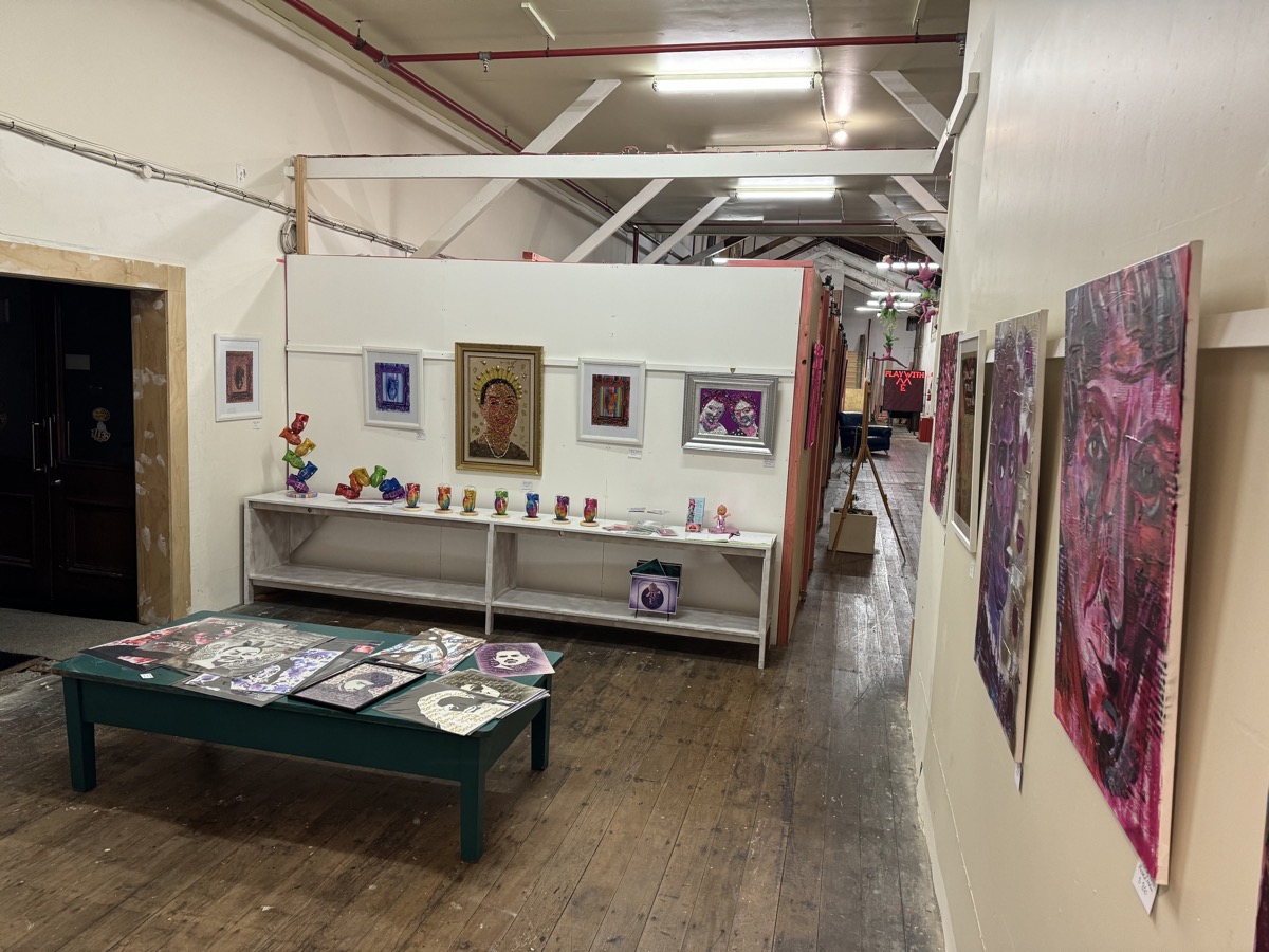 Gallery space inside the Ministry of Works Building with paintings and prints on display